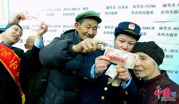 Industrial and commercial law enforcement officers teach people how to identify counterfeit money in a residential area in Jinzhou, Liaoning Province, on March 14, ahead of the Consumer Rights Day on March 15. [China.org.cn] 