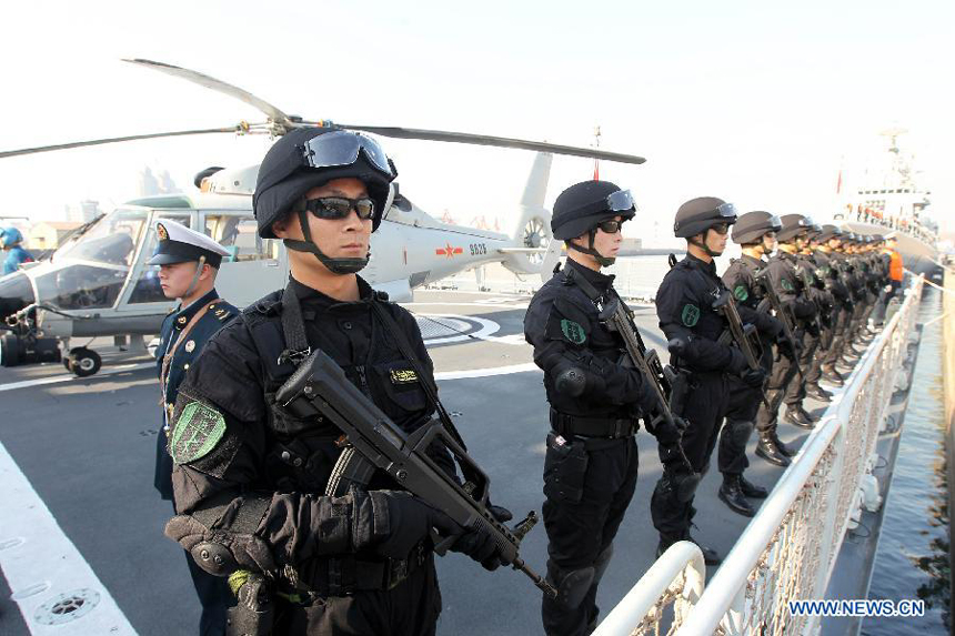 Special force soldiers stand guard on board and prepare to set sail at a port in Qingdao, east China's Shandong Province, Feb. 27, 2012. The 11th Chinese naval escort flotilla, consisting of destroyer 'Qingdao', frigate 'Yantai' and comprehensive supply ship 'Huishanhu', departed from Qingdao on Monday for the escort mission in the Gulf of Aden and Somali waters to protect commercial ships from pirate attacks.