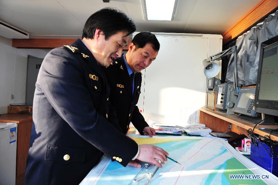 Commander Liu Zhendong (R) and captain Huang Qiquan study the cruise lines on China's patrol ship 'Haijian 50', which patrols in waters near the Diaoyu Islands, March 16, 2012. The patrol by China Marine Surveillance, the country's maritime law enforcement authorities, was carried out by two patrol ships 'Haijian 50' and 'Haijian 66', which arrived in waters near the Diaoyu Island and its affiliated isles in the early morning of Friday. Authorized by the Chinese State Council, the State Oceanic Administration (SOA), the country's maritime authority, and the Ministry of Civil Affairs released standard names of the Diaoyu Island and its affiliated isles recently. 