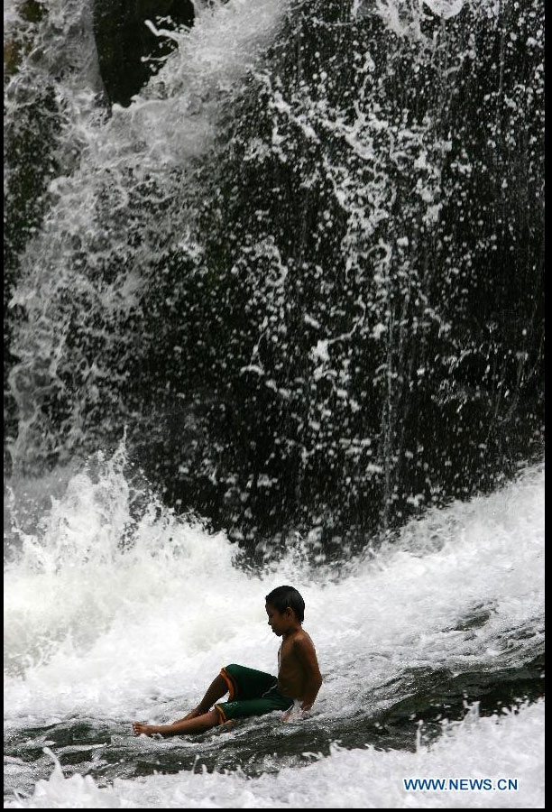Local tourists cool off in the Wawa Dam spillway in Rizal Province, the Philippines, on March 18, 2012. The Wawa Dam is an abandoned water reservoir that was turned into a travel destination for local and foreign tourists. (Xinhua/Rouelle Umali)