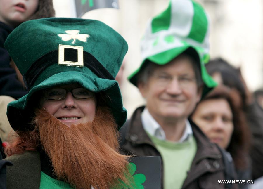 Spectators watch the St. Patrick's Day parade in central London, Britain, March 18, 2012. St. Patrick's Day is a religious holiday celebrated internationally on March 17. It is named after Saint Patrick, the most commonly recognized of the patron saints of Ireland. (Xinhua/Bimal Gautum)