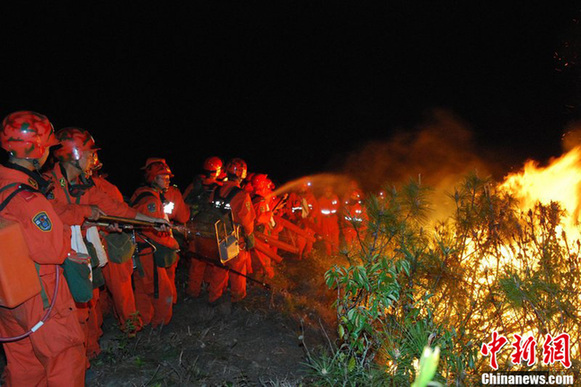 Firefighters try to put out forest fire spread to Caopu Township in Anning, a county-level city on the outskirts of Kunming, capital of southwest China's Yunnan Province, March 19, 2012. [Chinanews.com]