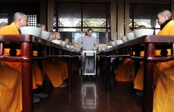 Students of the Buddhist Academy of Emei Mountain have lunch in Emei Mountain, southwest China's Sichuan province, March 16, 2012. Established in 1927, the school, covering an area of more than 10,000 square meters presently, has courses mainly on Buddhism studying. [Photo/Xinhua] 