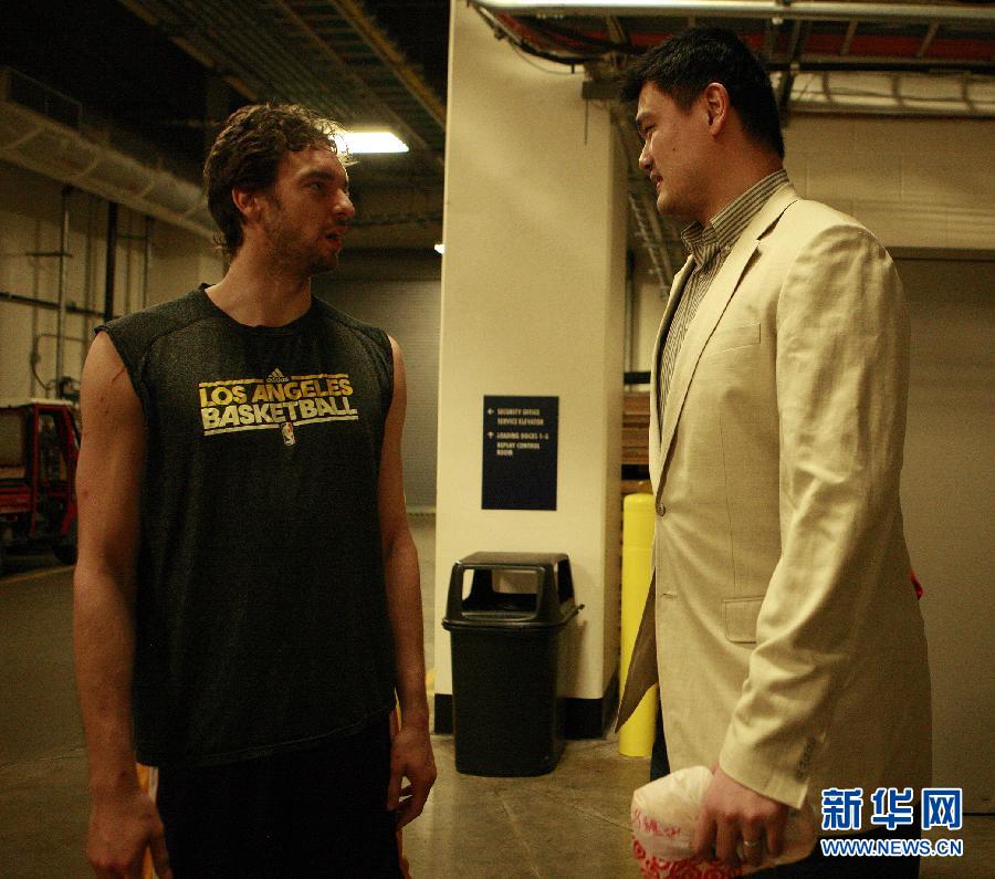 Former Houston Rockets center Yao Ming talks to Paul Gasol before an NBA basketball game betweeb Houston Rockets and LA Lakers onTuesday, March 20, 2012, in Houston. 