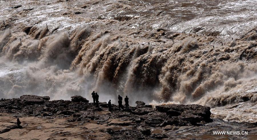 Visitors view the Hukou Waterfall of Yellow River in Jixian County, north China's Shanxi Province, March 24, 2012. The period from March to April, when peach flowers blossom, is one of the best times to view the Hukou Waterfall. (Xinhua/Lu Guiming) 