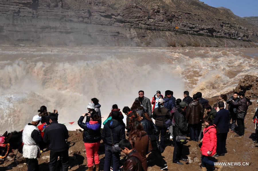 Visitors view the Hukou Waterfall of Yellow River in Jixian County, north China's Shanxi Province, March 24, 2012. The period from March to April, when peach flowers blossom, is one of the best times to view the Hukou Waterfall. (Xinhua/Lu Guiming) 