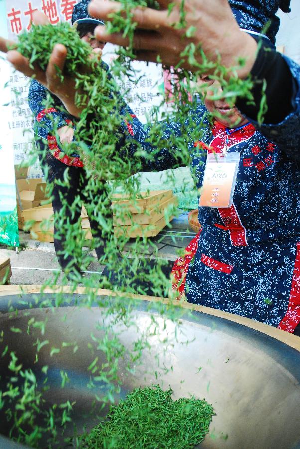A farmer processes the spring tea during a tea festival marking start of a pick season at Hufu Township of Yixing, east China's Jiangsu Province, March 25, 2012. Merchants, tourists and farmers gathered here to spend the festival Sunday. (Xinhua/Min Xueping) 