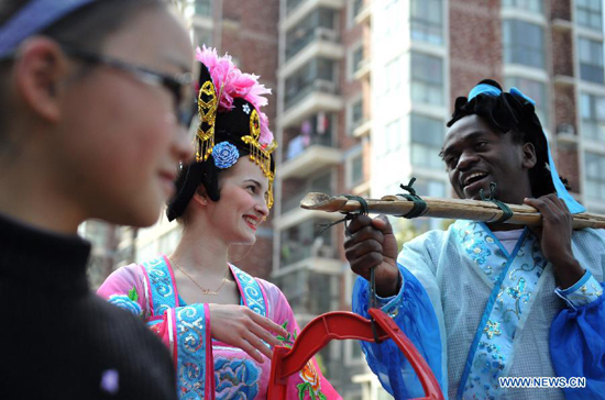 Two foreign students learn Huangmei Opera in Keqi Community of Hefei, capital of east China's Anhui Province, March 26, 2012. The community invited professional Huangmei Opera performers to give a lesson on Monday, to greet the World Theatre Day that falls on March 27. (Xinhua/Liu Junxi)