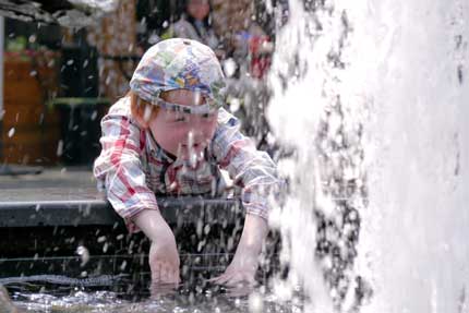 A child plays in a fountain yesterday at the Xintiandi entertainment complex on a day the mercury rose to 26.1 degrees Celsius, bringing a rousing confirmation that spring has arrived. 