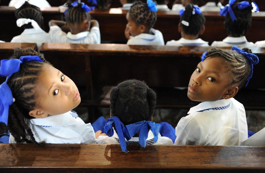 Students look back at the Cathedral of the Immaculate Conception in Port-of-Spain, capital of Trinidad and Tobago on March 27, 2012. The Cathedral, built in 1831, is one of the oldest churches in the Caribbean region. (Xinhua/Weng Xinyang) 