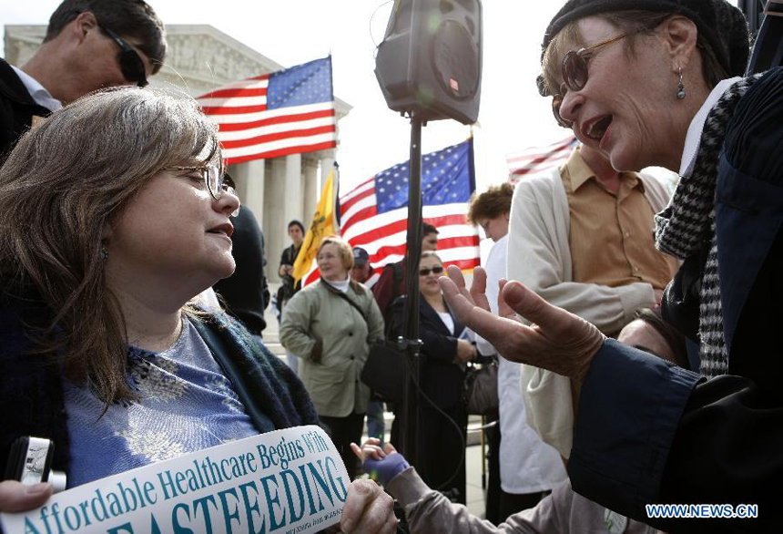 People argue for different point of views on Healthcare Act during a protest in front of the U.S. Supreme Court building in Washongton D.C., capital of the United States, on March 28, 2012. The U.S. Supreme Court on Wednesday entered its last day of oral arguments in the landmark case involving the Affordable Care Act, the signature healthcare overhaul of President Barack Obama.