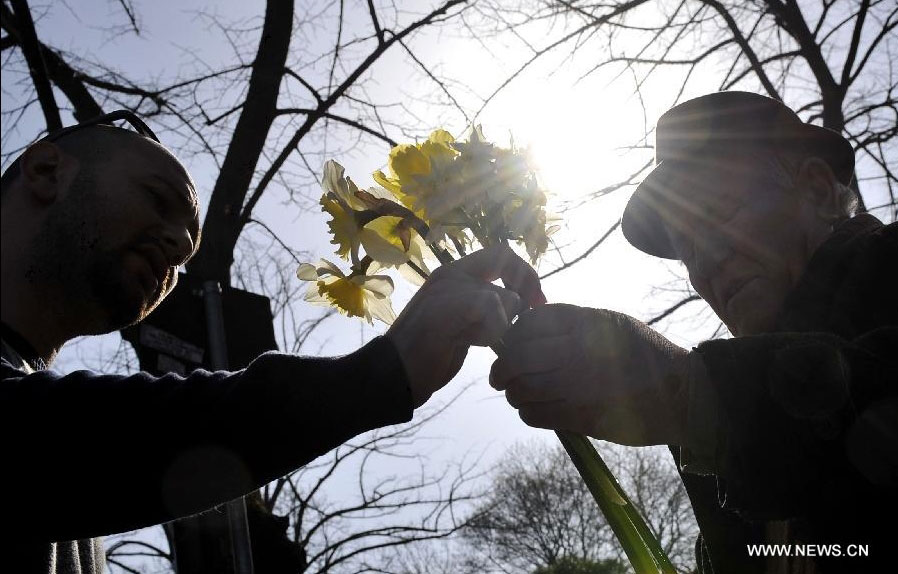 A vender (R) hands over a bunch of flowers to a man in Tirana, Albania, March 20, 2012. Varieties of spring flowers flourish as the northern hemisphere have entered its springtime since March. (Xinhua/Wu Wei) 