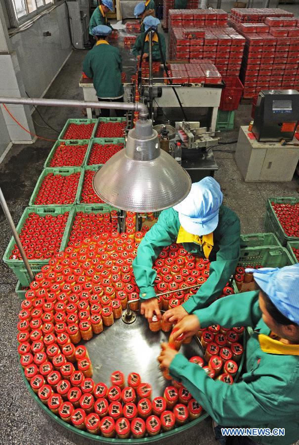 Employees sort bottles of pickled banboo shoots on the production line of a local food producer in Anji County, east China's Zhejiang Province, March 29, 2012. (Xinhua/Tan Jin) 