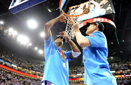 Beijing Ducks' Stephon Marbury (left) cuts the net as a souvenir with teammate Chen Lei after beating the Guangdong Southern Tigers in the CBA finals in Beijing last night. 
