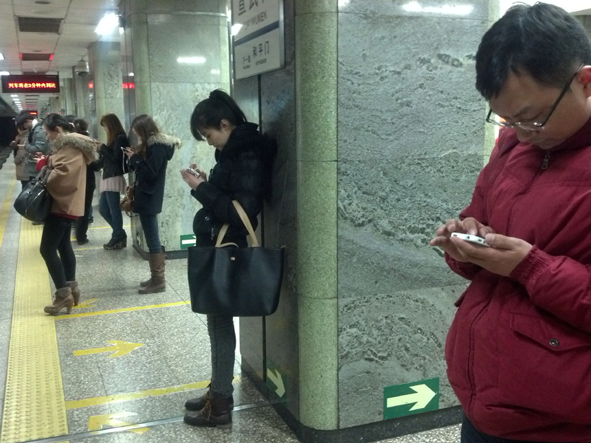 The number of Chinese mobile phone users topped 1 billion as of the end of February, the Ministry of Industry and Information Technology said on Mar. 30. 2012. In this picture, people use mobile phones in the Beijing Xuanwumen Subway Station. 