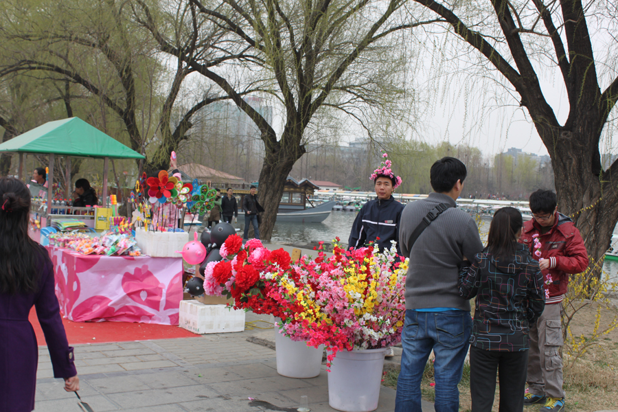 Visitors buy the artificial flowers while enjoying the blossoms in Yuyantan Park, in Beijing, April 3, 2012. [Photo/China.org.cn]
