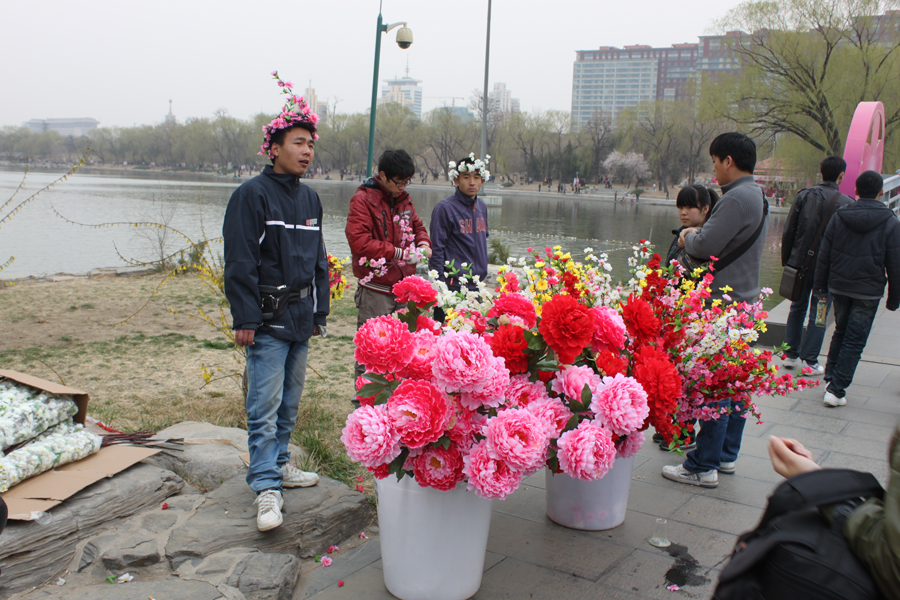 Visitors buy the artificial flowers while enjoying the blossoms in Yuyantan Park, in Beijing, April 3, 2012. [Photo/China.org.cn]