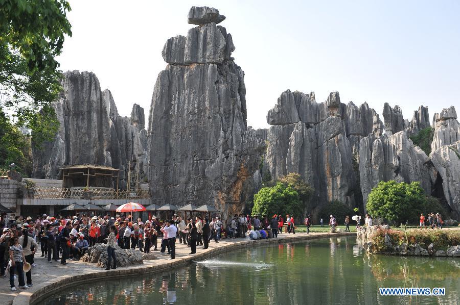 Tourists visit the Stone Forest Scenic Area in Kunming, capital of southwest China's Yunnan Province, April 2, 2012. As the weather turned warm in many places throughout China, a lot of people take the Qingming Festival holiday to go for an outing. [Xinhua]