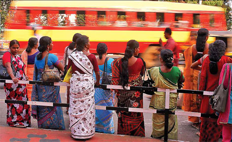 Indian women wait for bus in a street of Bangalore on Feb 29.[Source: China Daily]