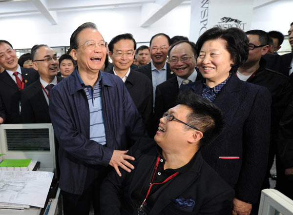 Chinese Premier Wen Jiabao talks with an employee of a sporting goods company in Quanzhou, East China's Fujian province, April 2, 2012. [Photo/Xinhua] 