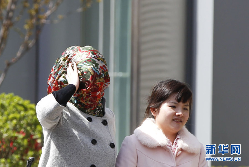 Two women walk against the gale in downtown Beijing, April 5. Meteorologists issue a strong wind warning early today. 