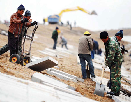 Workers construct an irrigation canal in Northeast China's Heilongjiang province, often dubbed the country's breadbasket. [Xinhua] 