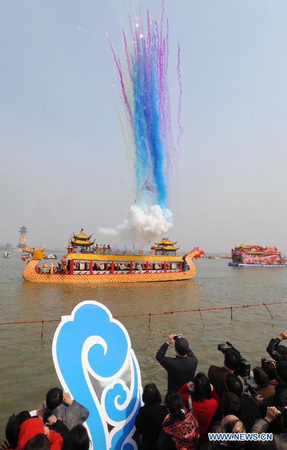 Spectators watch the parade of boats during the Boat Festival in the Qin Lake of Qintong Township, east China's Jiangsu Province, April 5, 2012. Qintong Boat Festival, an annual event since Southern Song Dynasty (1127-1279), is held here on Thursday, attracting lots of tourists. (Xinhua/Xu Hui) 