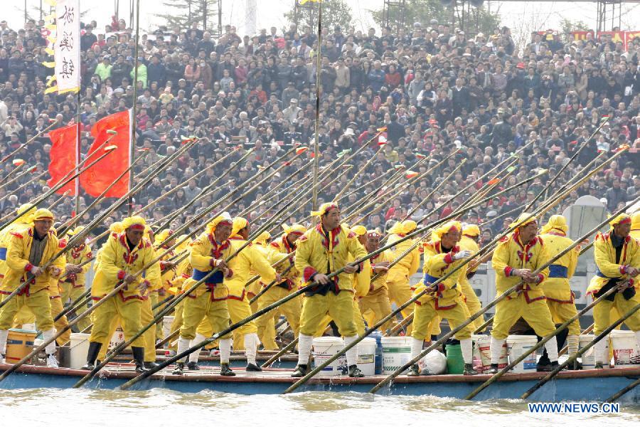 Participants row against other teams during the Boat Festival in the Qin Lake of Qintong Township, east China's Jiangsu Province, April 5, 2012. Qintong Boat Festival, an annual event since Southern Song Dynasty (1127-1279), is held here on Thursday, attracting lots of tourists. (Xinhua/Xu Hui) 