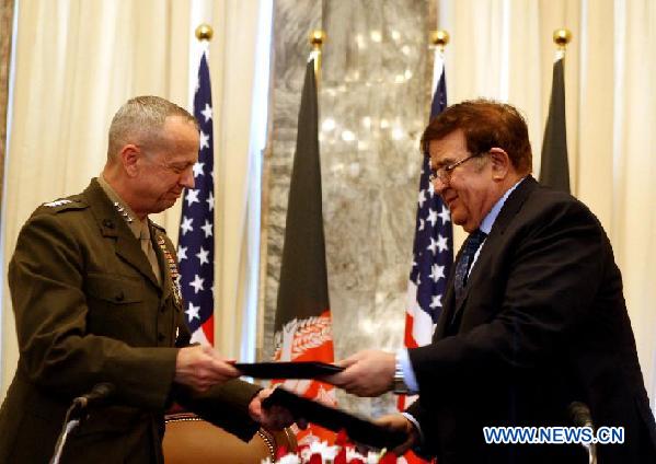 Afghan Defense Minister General Abdul Rahim Wardak (R) exchanges agreement with General John Allen, the top U.S. and NATO commander in Afghanistan, during a joint news press conference in Kabul, Afghanistan, on April 8, 2012. The Afghan government and the U.S. forces signed an agreement in Kabul Sunday afternoon to hand over all special operations including the controversial night raid operations from U.S. and NATO forces to Afghan soldiers, the Afghan Foreign Ministry said on Sunday. [Ahmad Massoud/Xinhua]