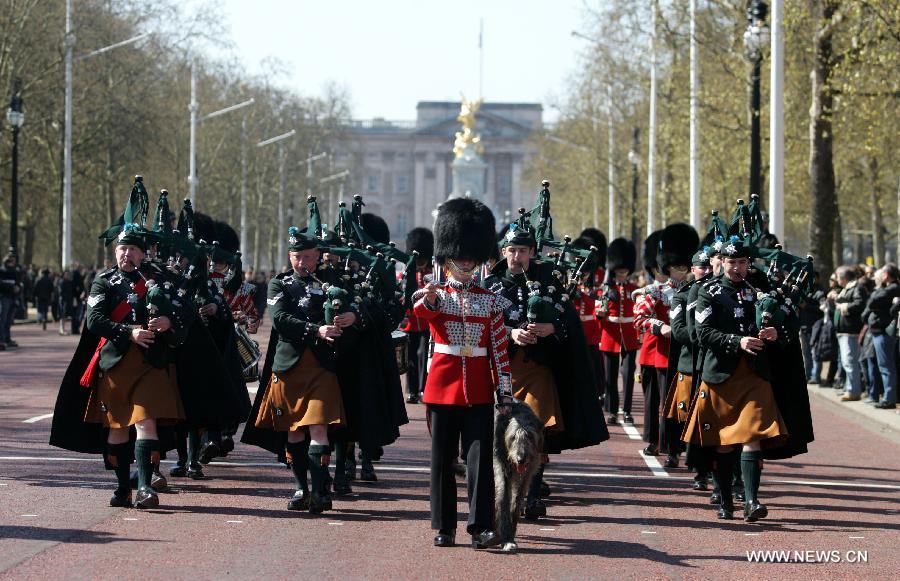 People proceed during a parade marking Good Friday in front of the Buckingham Palace in London, Britain, April 6, 2012.(Xinhua/Bimal Gautam)