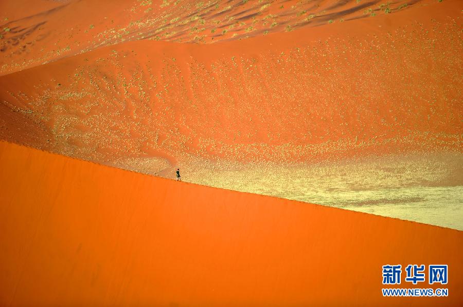  A tourist walks on the red sand dune in Sossusvlei desert park, Namibia, April 9, 2012. (Xinhua Photo) 