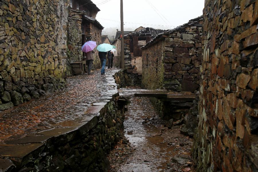 Residents walk on a road at Xujiashan village in Ninghai County, southeast China's Zhejiang Province, April 9, 2012. As most of the houses and roads in Xujiashan village was built with the basalt, it is also known as the stone village. 