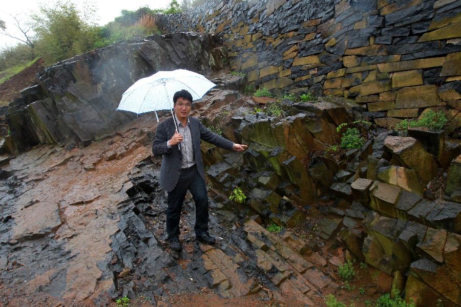 A man shows the basalt for construction at Xujiashan village in Ninghai county, southeast China's Zhejiang Province, April 9, 2012. As most of the houses and roads in Xujiashan village was built with the basalt, it is also known as the stone village.