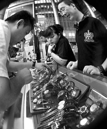 Customers choose luxury watches at a high-end store in Shanghai. China is likely to become the world's largest luxury watch consumer in 2012 and have sales surpassing 210,000.[China Daily]