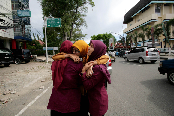 Acehnese women hug each other and pray shortly after a powerfull earthquake hit the western coast of Sumatera in Banda Aceh on April 11, 2012. A massive earthquake struck off Indonesia's Sumatra island, US and Indonesian monitors reported, prompting an Indian Ocean-wide tsunami alert. 