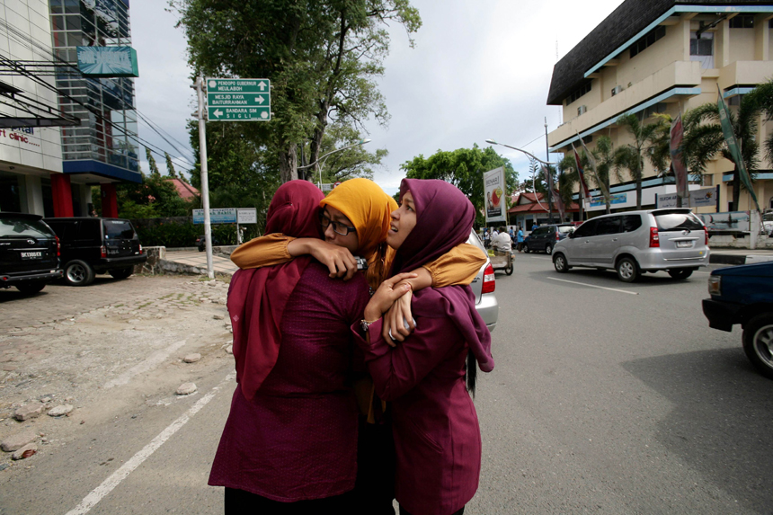 Acehnese women hug each other and pray shortly after a powerfull earthquake hit the western coast of Sumatera in Banda Aceh on April 11, 2012. A massive earthquake struck off Indonesia's Sumatra island, US and Indonesian monitors reported, prompting an Indian Ocean-wide tsunami alert. [Xinhua photo]