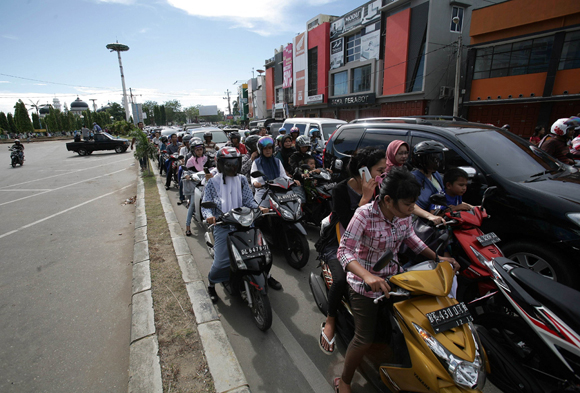 Acehnese people try to go to higher ground after a powerfull earthquake hit the western coast of Sumatera in Banda Aceh on April 11, 2012. A massive earthquake struck off Indonesia's Sumatra island, US and Indonesian monitors reported, prompting an Indian Ocean-wide tsunami alert. [Xinhua photo]