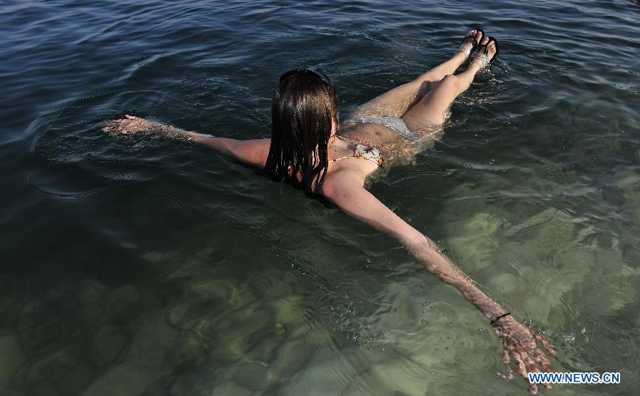  A girl enjoys sunbathe in the Dead Sea near Israeli En Gedi Nature Reserve during the Passover holiday on April 10, 2012. The Jewish holiday of Passover, which marks the exodus of the Jewish people from Egypt and from slavery to freedom, is celebrated this year between sunset on April 7 to sunset on April 13.(Xinhua/Yin Dongxun) 