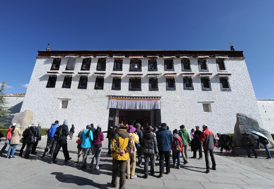 Tourists enter the Potala Palace in Lhasa, southwest China's Tibet Autonomous Region, April 12, 2012. The Potala Palace will extend its opening hours during the rush season to meet tourists' demand, the palace's administration said recently. (Xinhua/Wen Tao) 