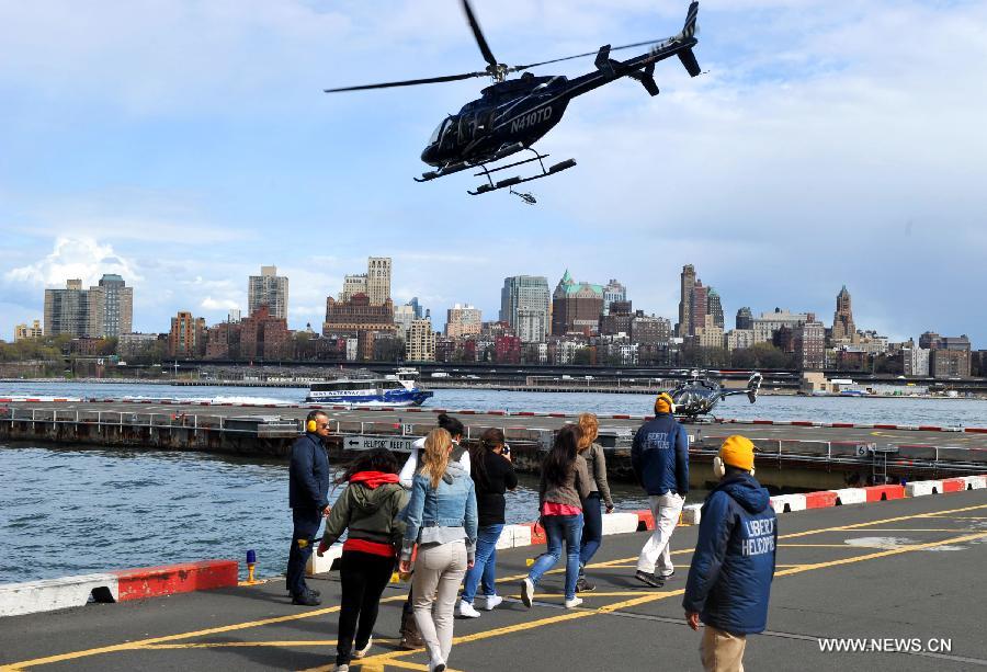 Tourists wait to aboard a helicopter to see the Manhattan skyline in New York City, the United States, April 12, 2012. (Xinhua/Wang Lei) 