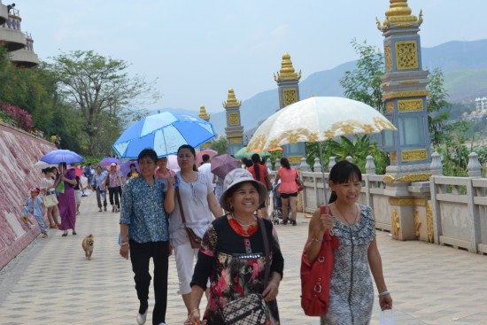 Visitors walk along the scenic Mekong River promenade in Jinghong City, Yunnan Province, Apr. 13. [Photo by Corey Cooper/China.org.cn]