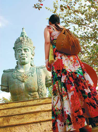 A tourist visits the biggest bronze statue in Bali, Indonesia. Peng Huan / for China Daily)