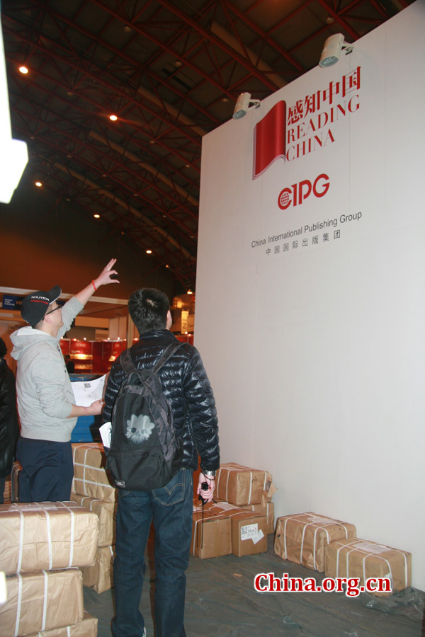 A CIPG employee and a decorator discuss the design of the CIPG booth during the London Book Fair.