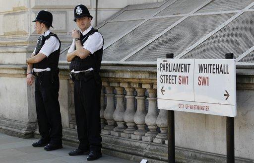 Police officers keeps watch in Westminster near the London 2012 beach volleyball venue, in London, Wednesday, March 28, 2012.