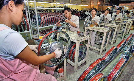 Workers assemble wheel hubs at a plant in Hung Yen province in Vietnam. The plant has received investment from the Chinese motorcycle and automobile maker Lifan Group Corp. China's outbound direct investment in non-financial sectors increased by 94.5 percent year-on-year in the first quarter of the year, hitting $16.55 billion. [Xinhua]