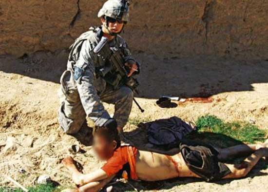 US soldier posing next to the corpse of Gul Mudin, an unarmed Afghan civilian killed by their unit on Jan. 15, 2010.