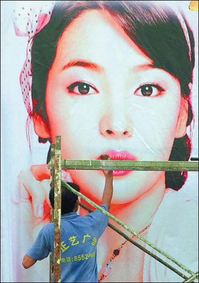 A worker preparing an outdoor advertising board in Nanjing, Jiangsu province. China's advertising market is growing rapidly, but the main players remain foreign firms. [File photo]