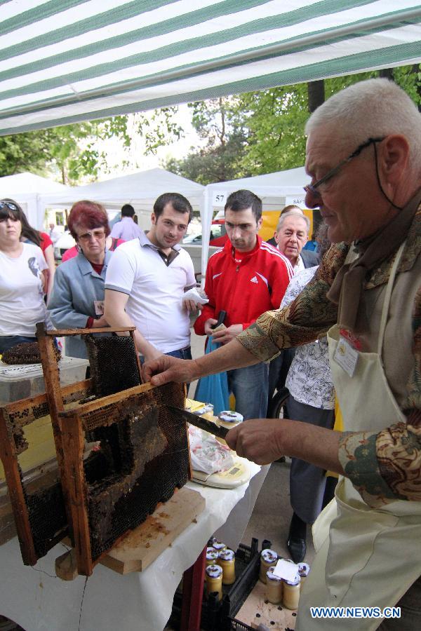 A bee keeper sells fresh honeycomb at the Honey Fair in Bucharest, capital of Romania, April 22, 2012. (Xinhua/Gabriel Petrescu) 