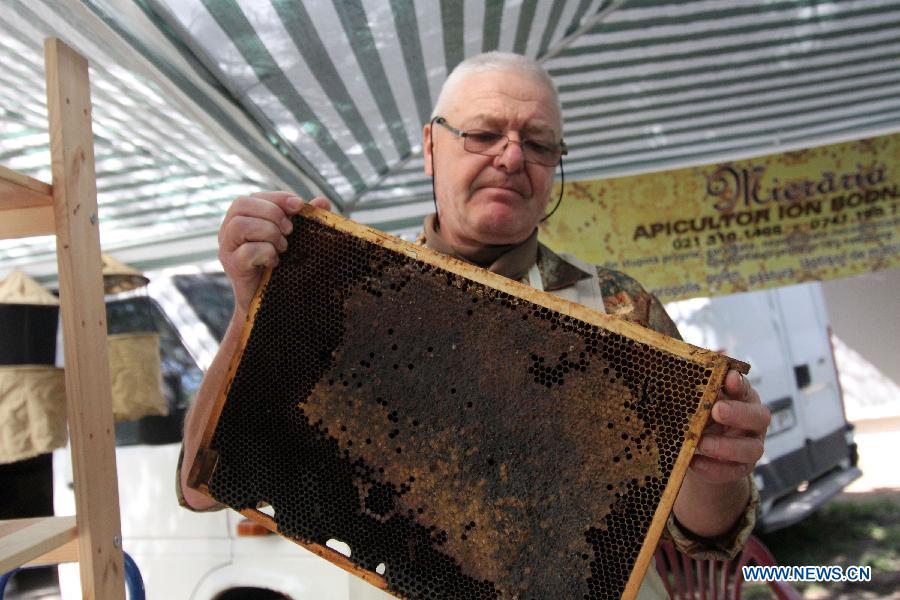  A bee keeper sells fresh honeycomb at the Honey Fair in Bucharest, capital of Romania, April 22, 2012. (Xinhua/Gabriel Petrescu) 
