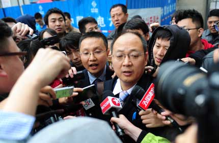 Jin Xiaoguang (center right) and Chen Gang (center left), lawyers for former Chinese Football Association deputy chief Xie Yalong are surrounded by reporters during a court recess yesterday in Dandong, Liaoning Province.